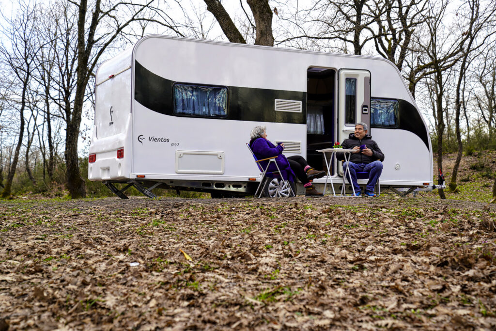 Karavan fotoğrafı: ormanda park edilmiş Gencer Karavan ve önünde oturan iki kişi